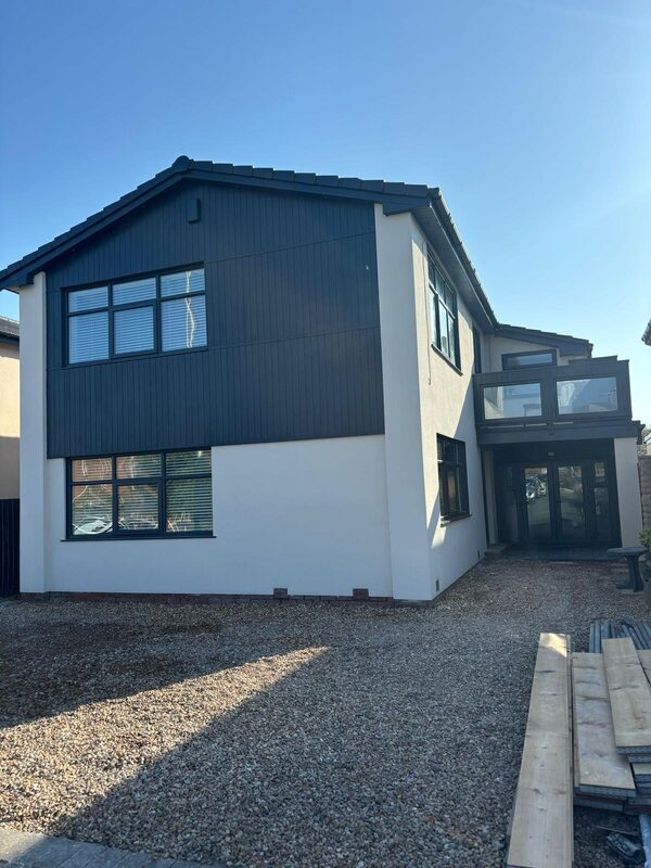 Modern house renovation with dark cladding and white render in Blackpool